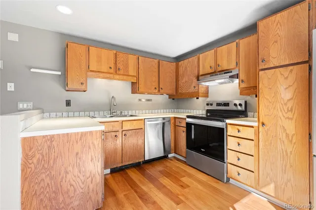 a kitchen with a refrigerator sink and cabinets