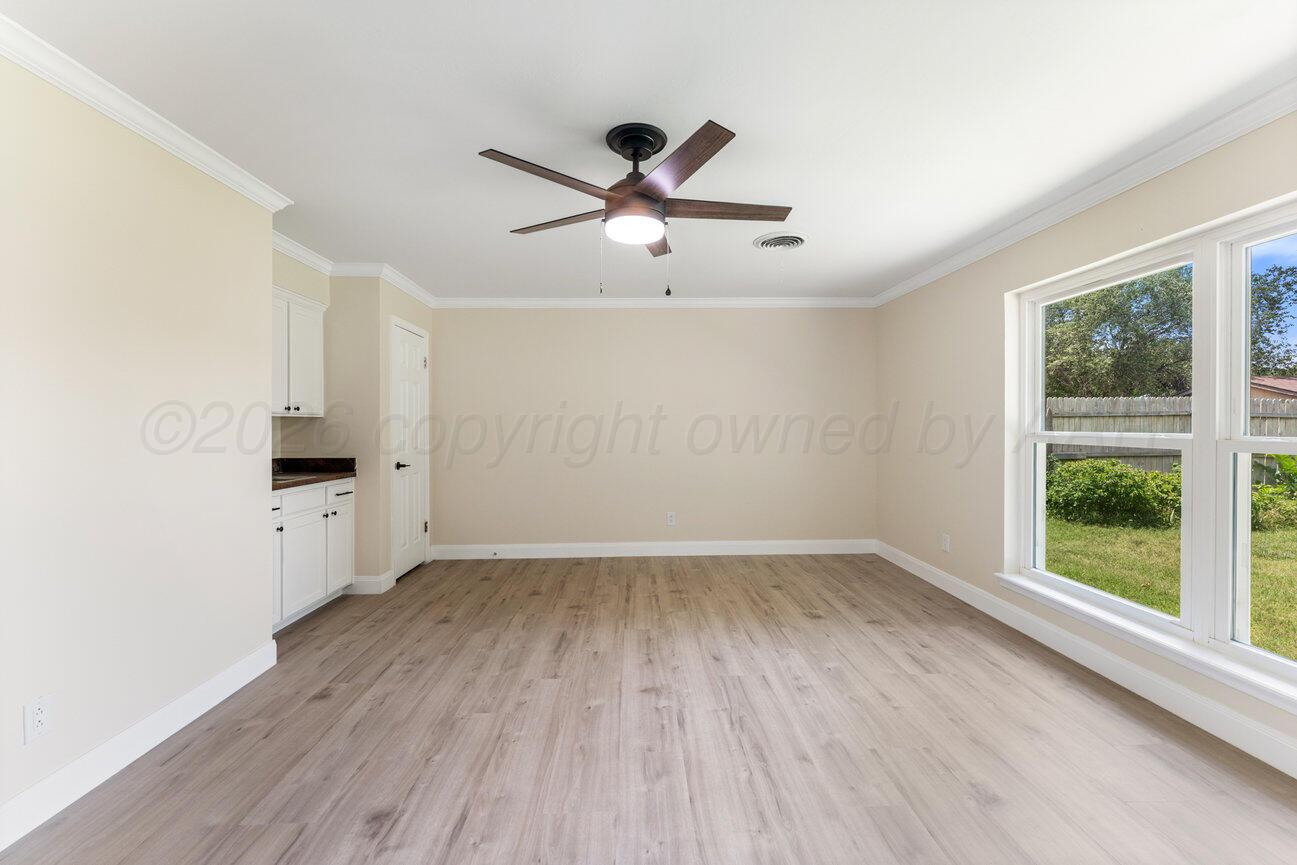 7204 Southwest 39th Avenue Amarillo, TX 79109 - Photo 20 of 51 an empty room with wooden floor a ceiling fan and windows