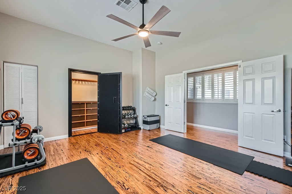 647 Foxhall Road Henderson, NV 89002 - Photo 24 of 82 Workout area featuring visible vents, baseboards, wood finished floors, a ceiling fan, and vaulted ceiling