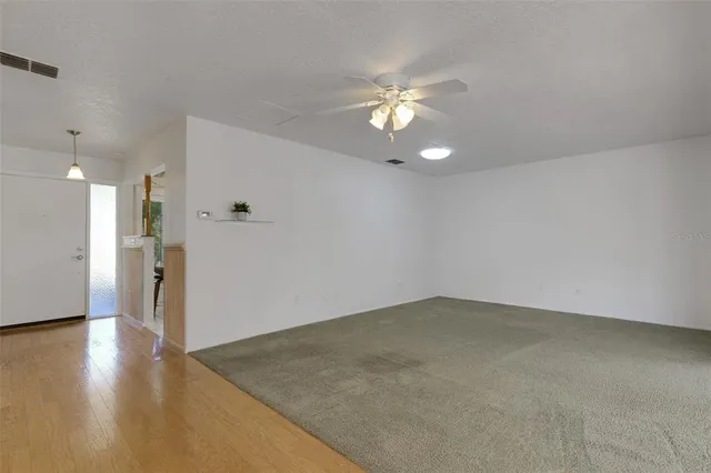 a view of a livingroom with a fireplace wooden floor and windows