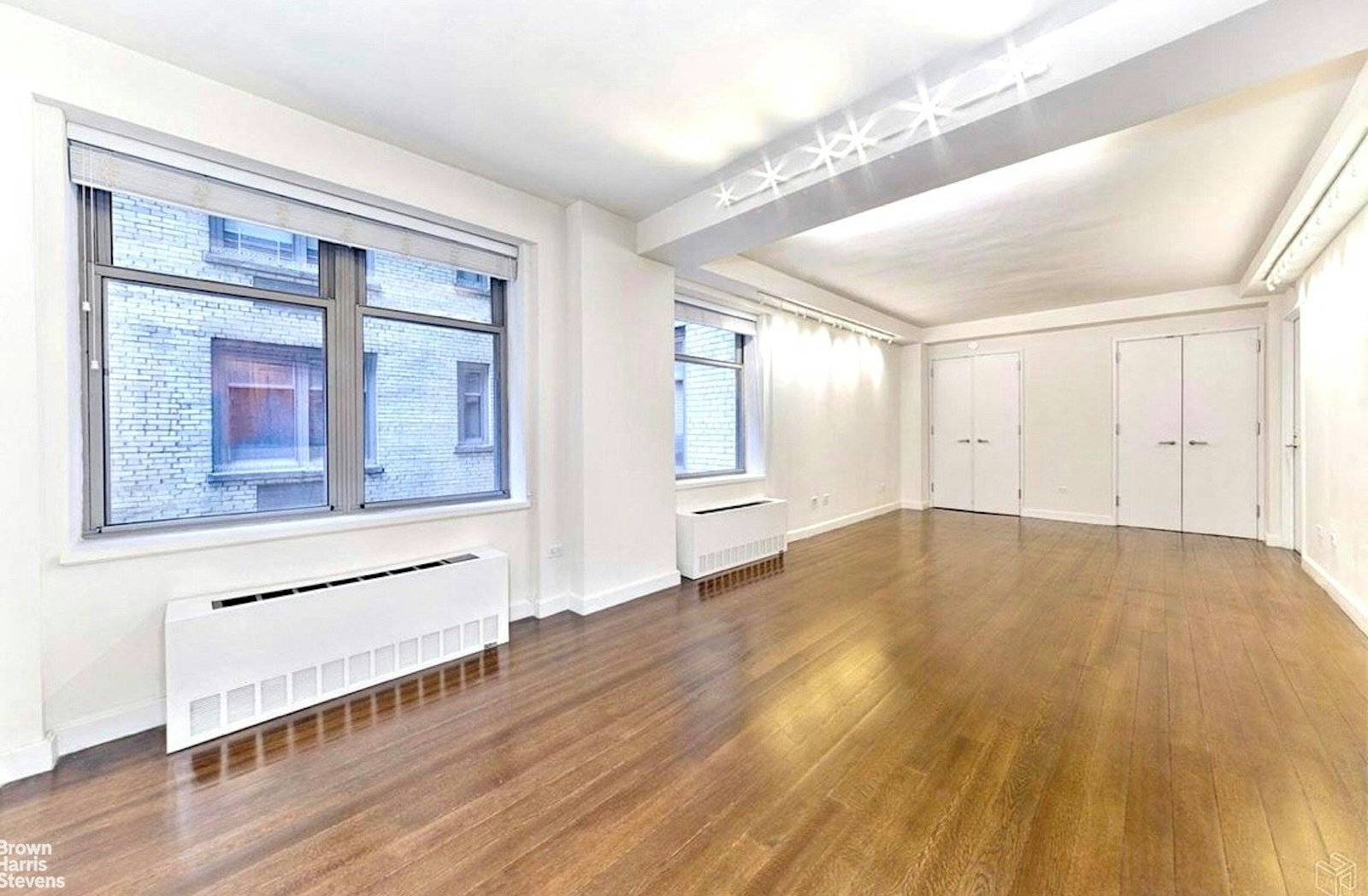 100 West 58th Street, Unit 5A Manhattan, NY 10019 - Photo 3 of 10 a view of empty room with wooden floor and fan