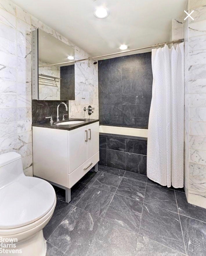 100 West 58th Street, Unit 5A Manhattan, NY 10019 - Photo 5 of 10 a bathroom with a sink a toilet and a tub