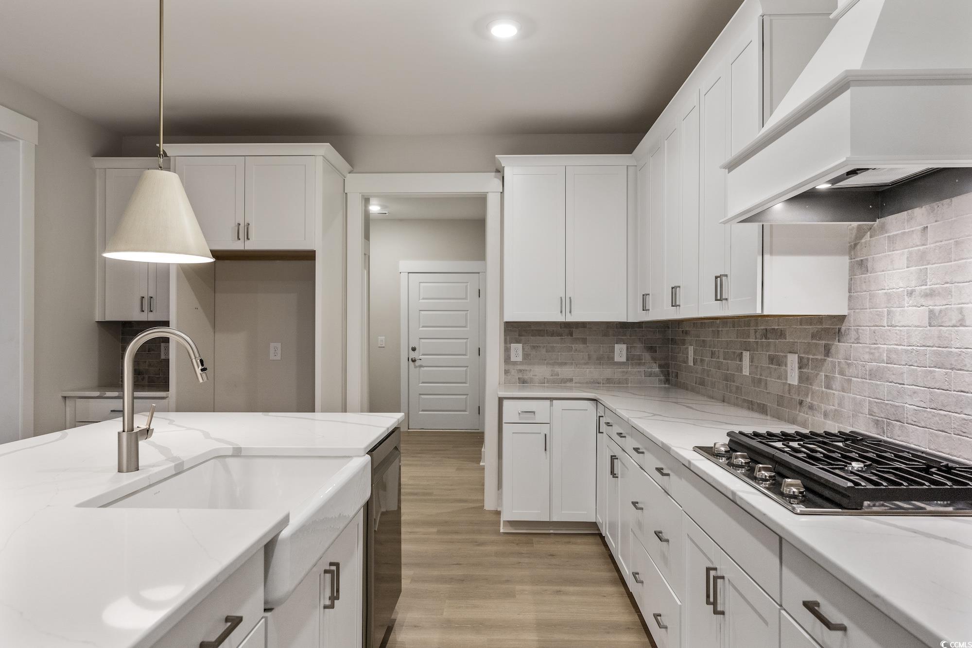 719 Daisy Bank Circle Georgetown, SC 29440 - Photo 14 of 33 Kitchen with white cabinets, decorative light fixtures, light wood finished floors, appliances with stainless steel finishes, and custom range hood
