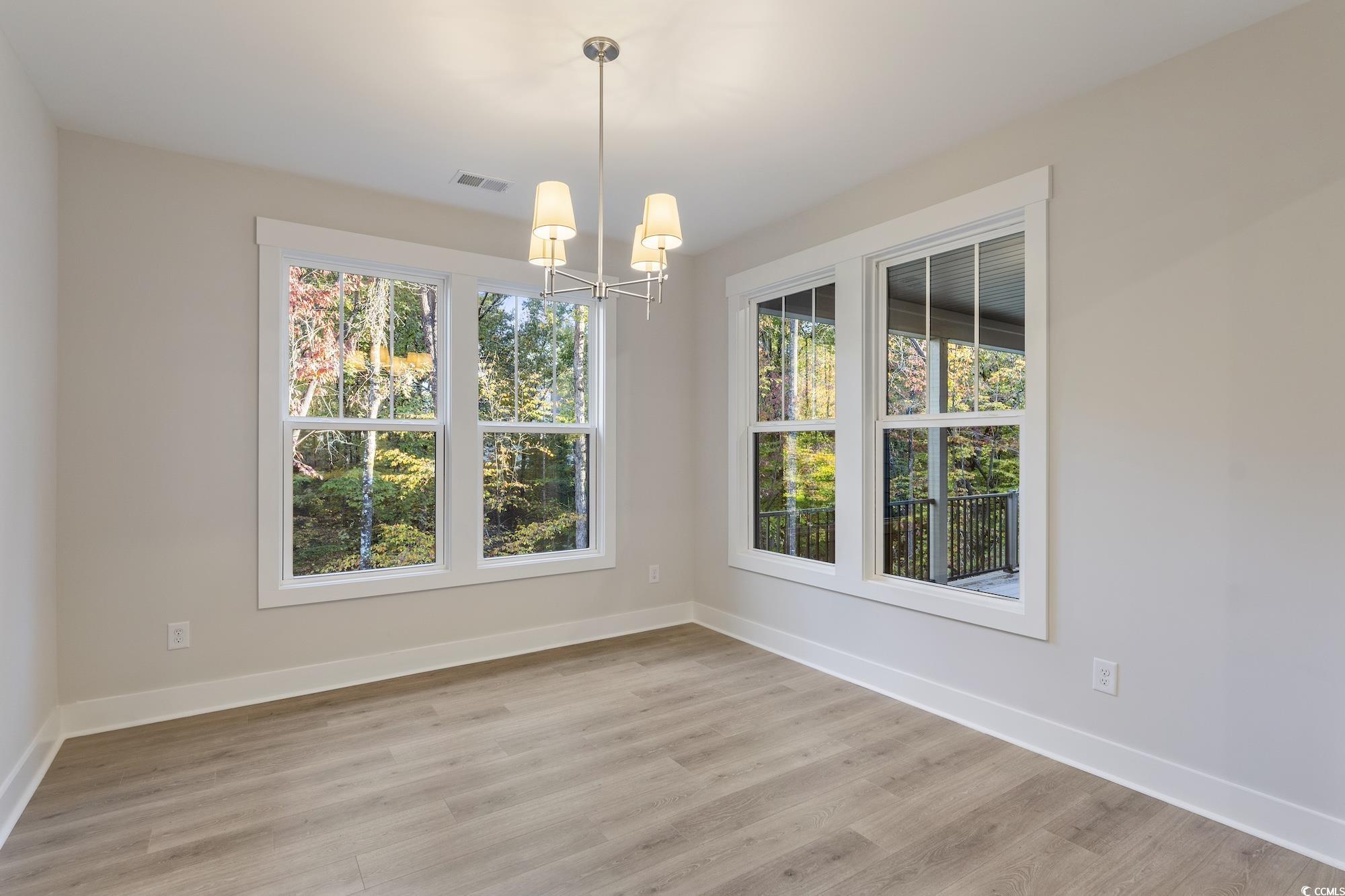 719 Daisy Bank Circle Georgetown, SC 29440 - Photo 15 of 33 Unfurnished dining area featuring a chandelier and light wood-type flooring