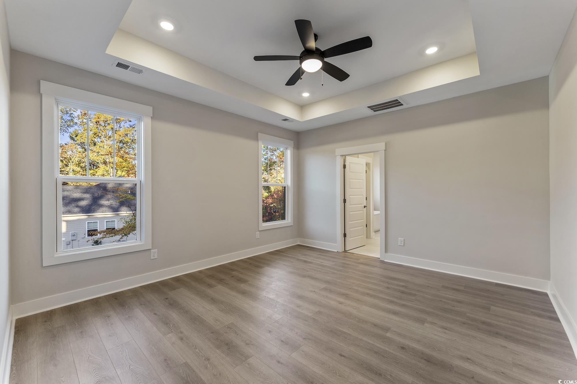 719 Daisy Bank Circle Georgetown, SC 29440 - Photo 19 of 33 Unfurnished bedroom with a tray ceiling, wood finished floors, a ceiling fan, and recessed lighting