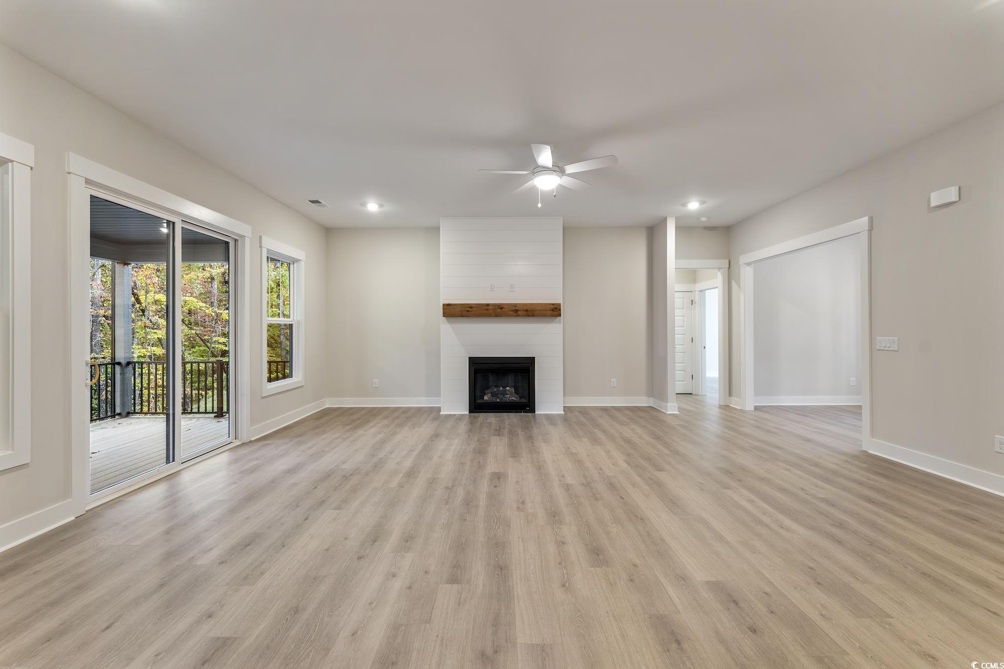 719 Daisy Bank Circle Georgetown, SC 29440 - Photo 7 of 33 Unfurnished living room featuring light wood finished floors, a ceiling fan, a fireplace, and recessed lighting