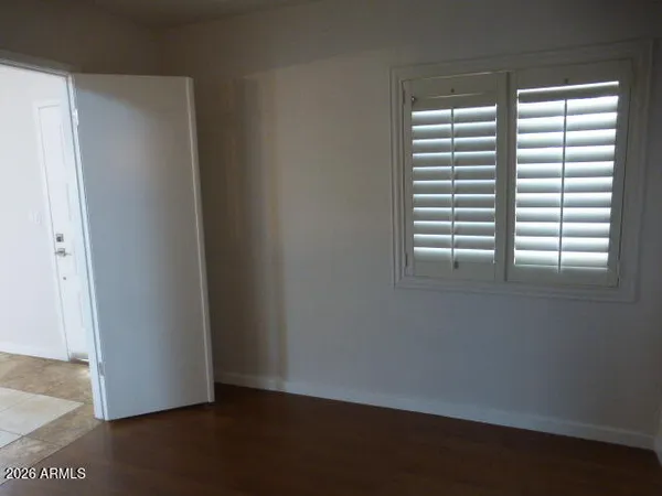 a view of empty room with window and chandelier fan
