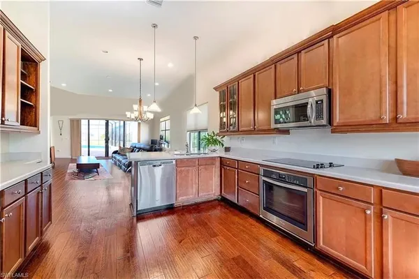a kitchen with stainless steel appliances kitchen island granite countertop a stove a sink and a microwave