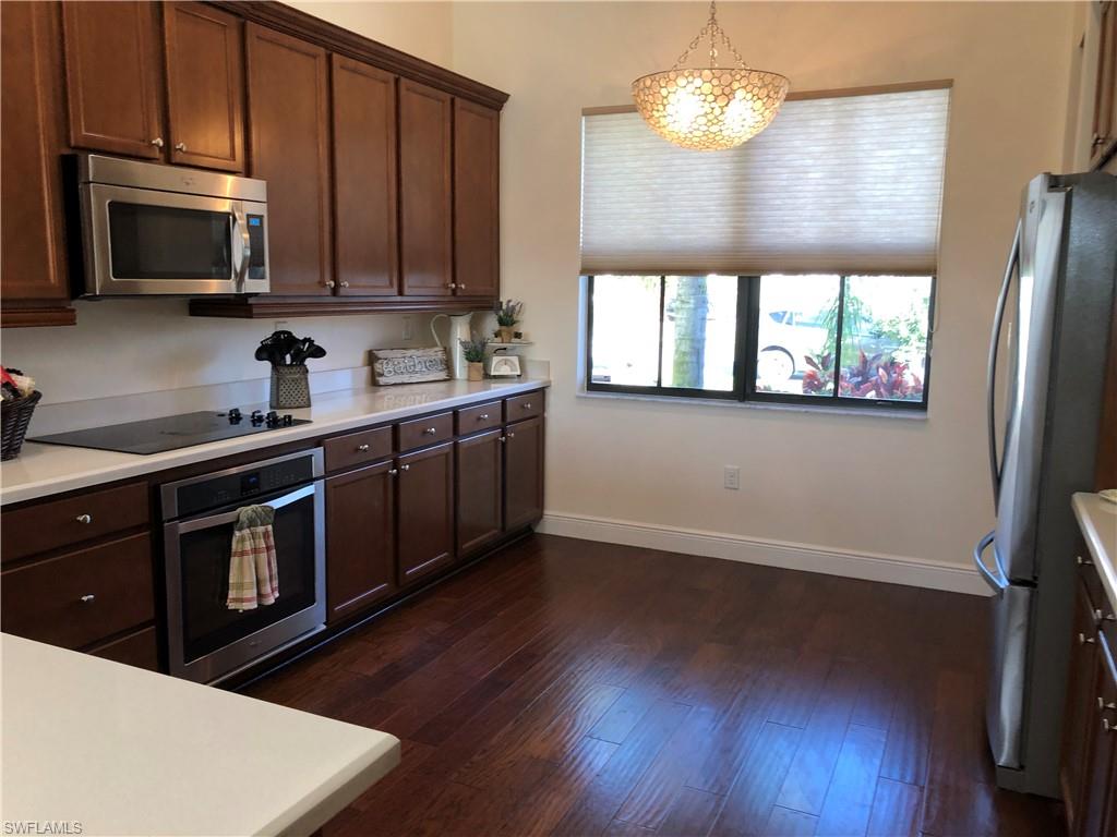 5351 Ferrari Avenue Ave Maria, FL 34142 - Photo 5 of 24 a kitchen with stainless steel appliances a microwave a stove a microwave and wooden floors