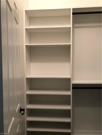 a view of walk in closet with empty racks