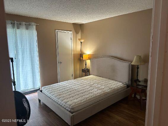 10200 Belle Rive Boulevard, Unit 239 Jacksonville, FL 32256 - Photo 11 of 27 a bedroom with a bed and a dresser with wooden floor
