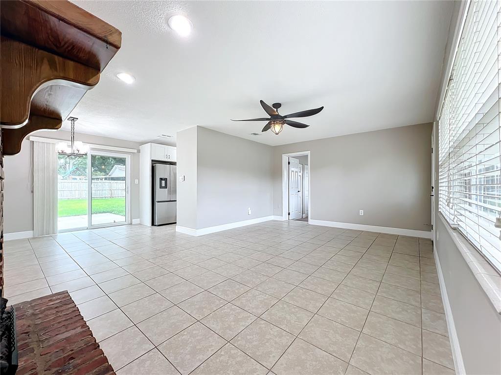 600 Ridgefield Avenue Ocoee, FL 34761 - Photo 16 of 45 Electric Fireplace in living room with ceramic tile floors, upgraded baseboards, new ceiling fan and insulated beveled glass front door opens to dinging area and kitchen.