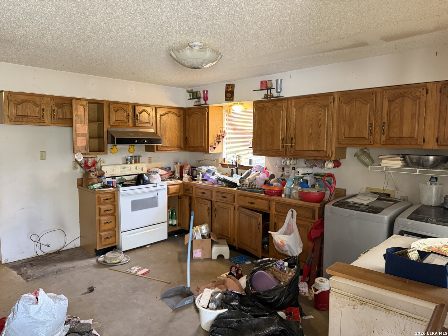 354 6th Poteet, TX 78065 - Photo 11 of 11 a room with kitchen island a stove a sink and a refrigerator