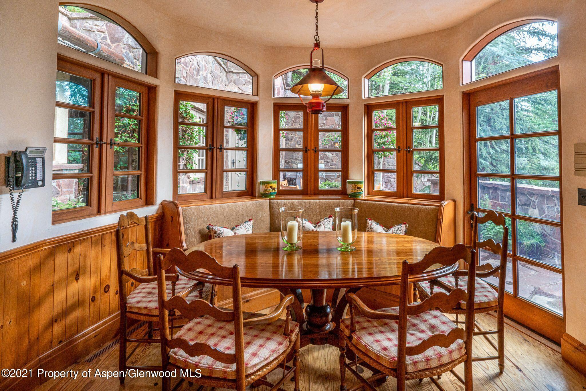 2137 Red Mountain Road Aspen, CO 81612 - Photo 22 of 59 a view of a dining room with furniture large windows and wooden floor