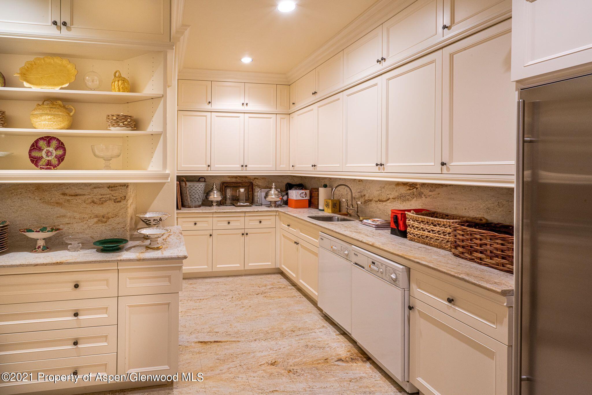2137 Red Mountain Road Aspen, CO 81612 - Photo 25 of 59 a kitchen with granite countertop white cabinets and white appliances