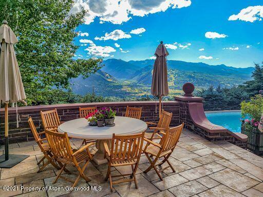 2137 Red Mountain Road Aspen, CO 81612 - Photo 3 of 59 a view of a patio with a table chairs and a garden