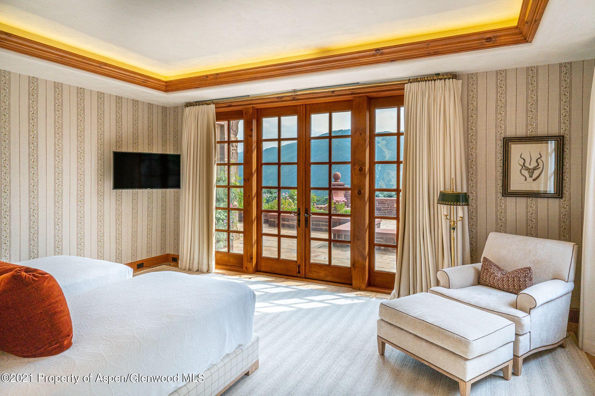 2137 Red Mountain Road Aspen, CO 81612 - Photo 40 of 59 a bedroom with a bed and a flat tv screen next to a window