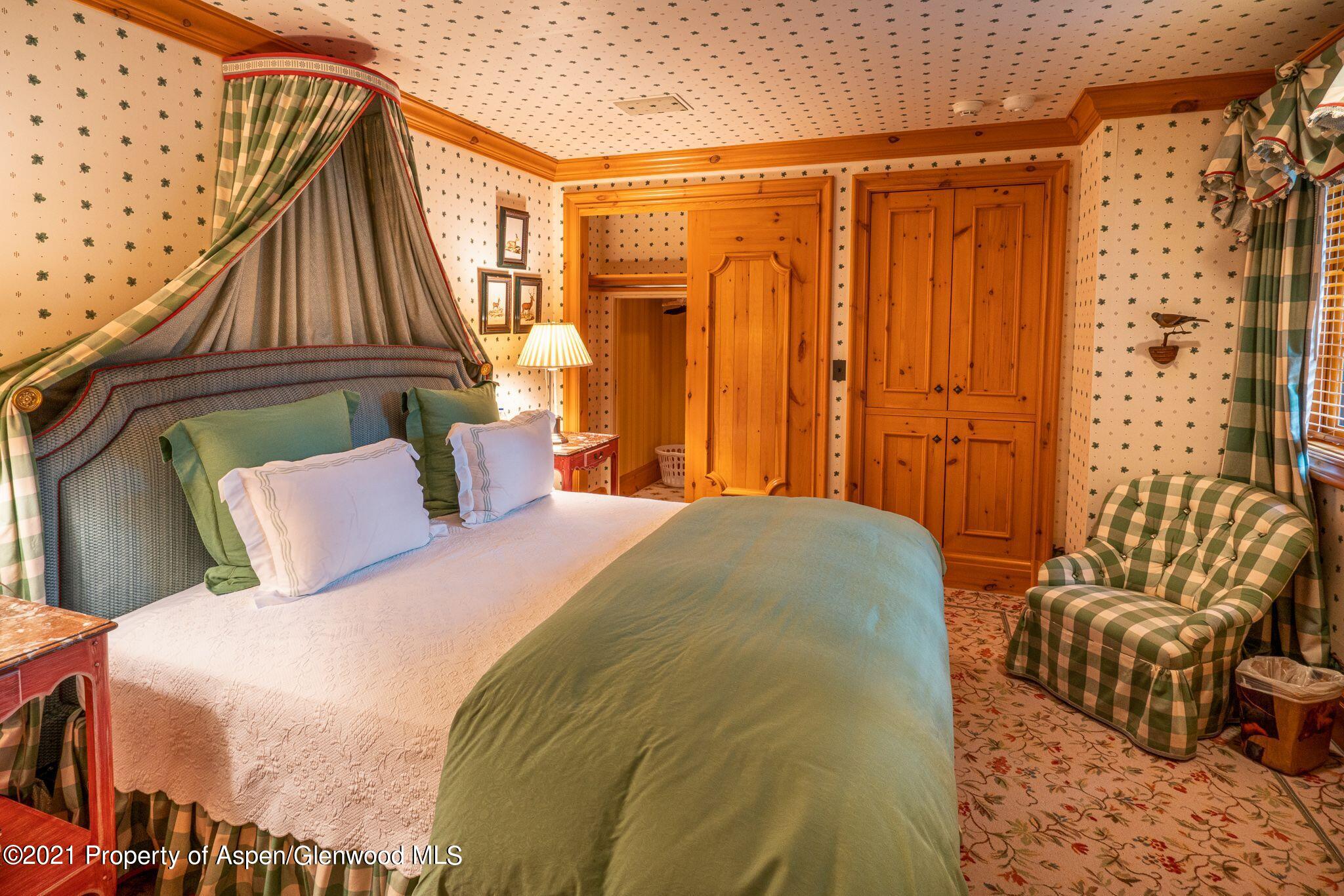 2137 Red Mountain Road Aspen, CO 81612 - Photo 45 of 59 a bedroom with a bed and wooden floor