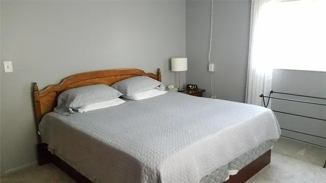 a bedroom with a bed and a refrigerator