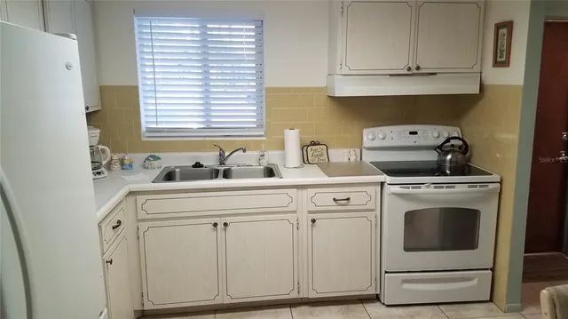 a kitchen with white cabinets and white appliances