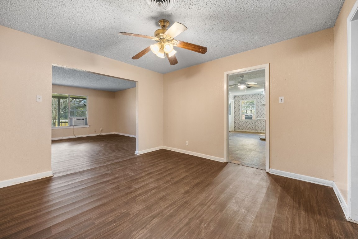 13038 4th Street Santa Fe, TX 77510 - Photo 7 of 39 an empty room with wooden floor chandelier and windows