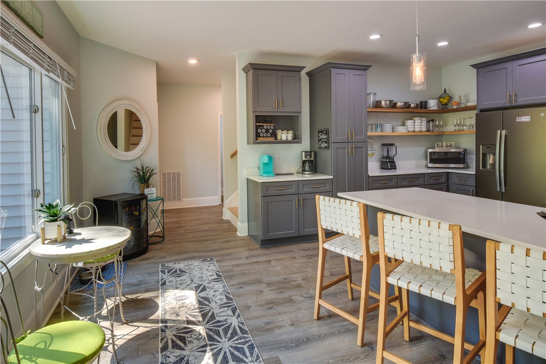 206 Petty Road Seneca, SC 29672 - Photo 12 of 48 A contemporary kitchen features sleek gray cabinetry, a breakfast bar, and open shelving, creating a stylish and functional space.