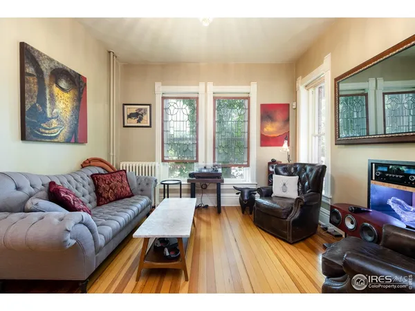 a living room with furniture fireplace and a large window