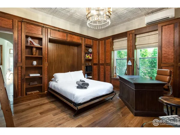 a view of a livingroom with bookshelf and a potted plant