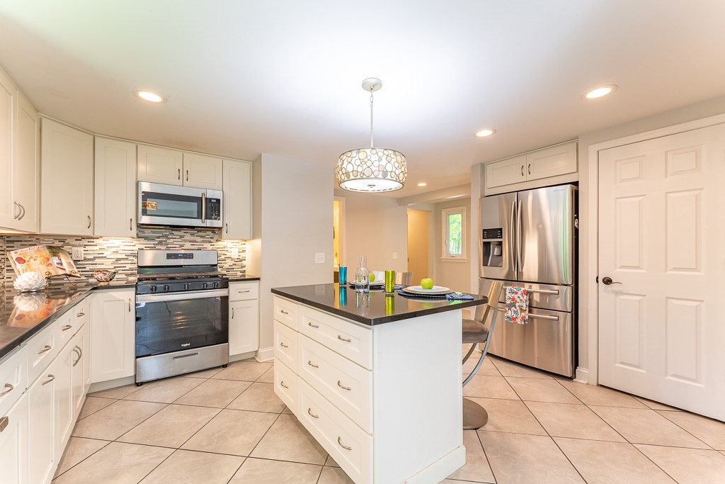 220 Hibiscus Drive Rochester, NY 14618 - Photo 12 of 50 The island, illuminated by a contemporary fixture, offers seating, storage, and a natural place to gather