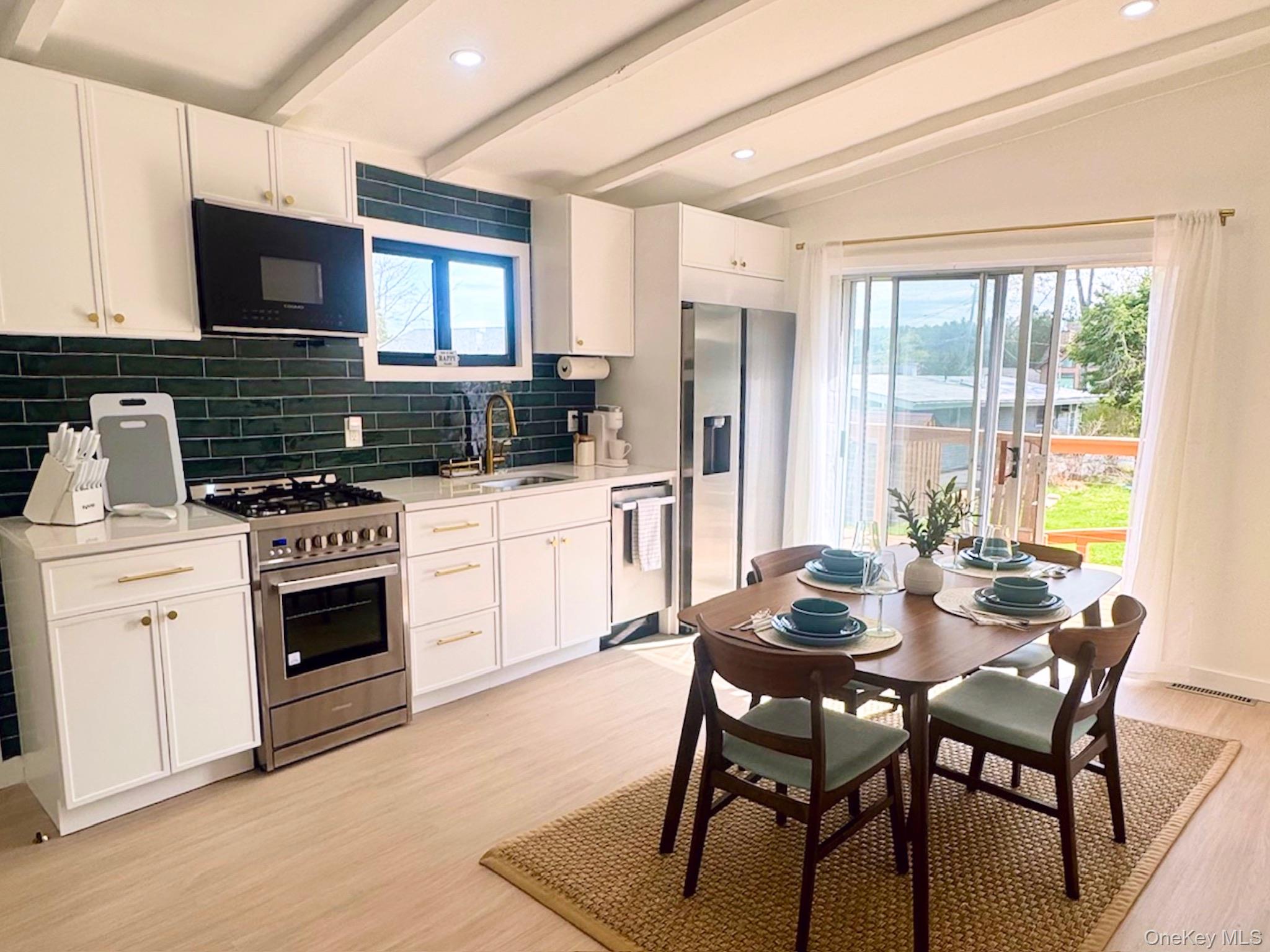 67 West Shore Road Kauneonga Lake, NY 12749 - Photo 3 of 17 Kitchen with appliances with stainless steel finishes, a sink, decorative backsplash, light wood-style flooring, and light countertops