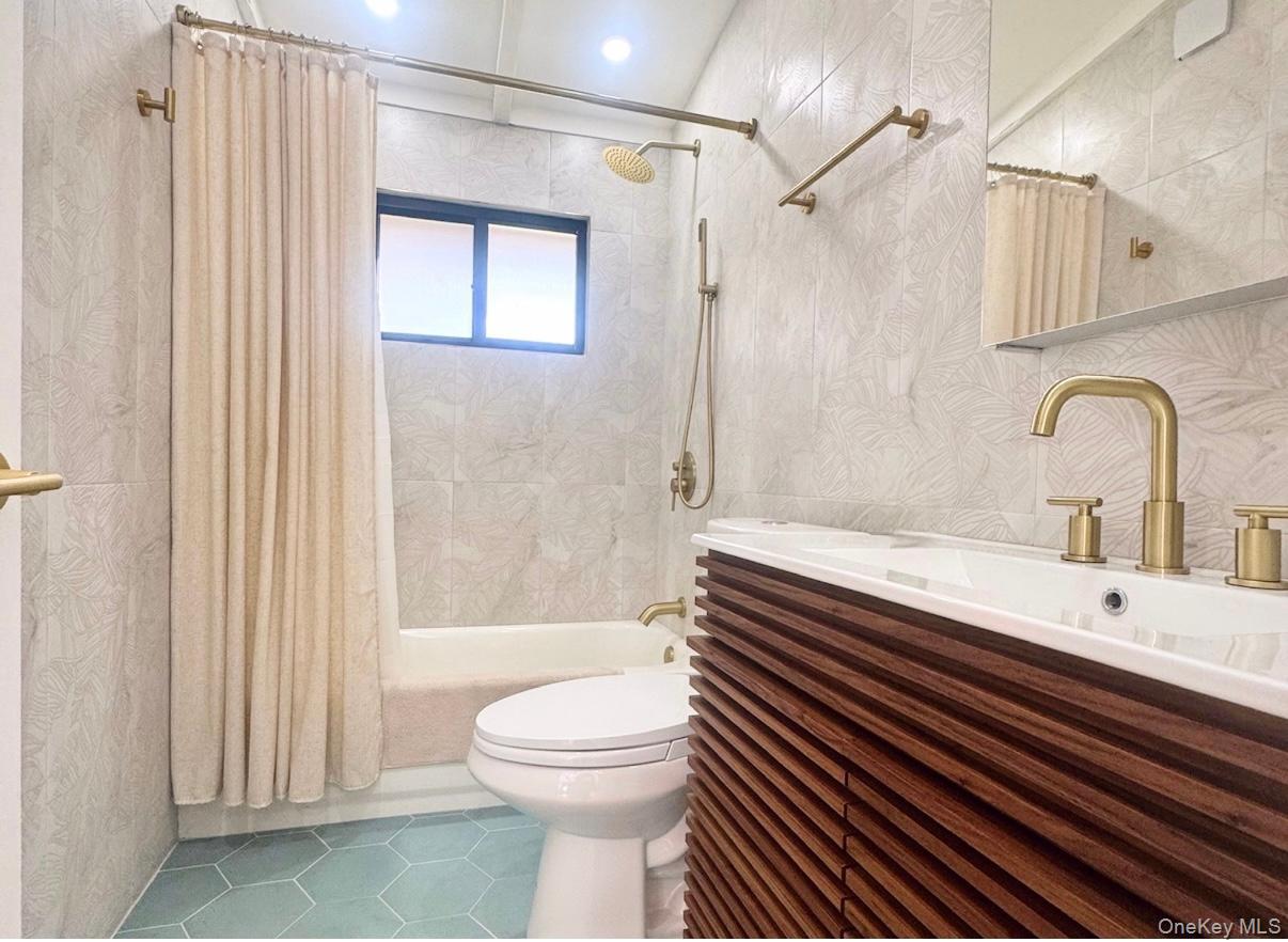 67 West Shore Road Kauneonga Lake, NY 12749 - Photo 6 of 17 Full bath with tile patterned floors, shower / bathtub combination with curtain, toilet, and vanity