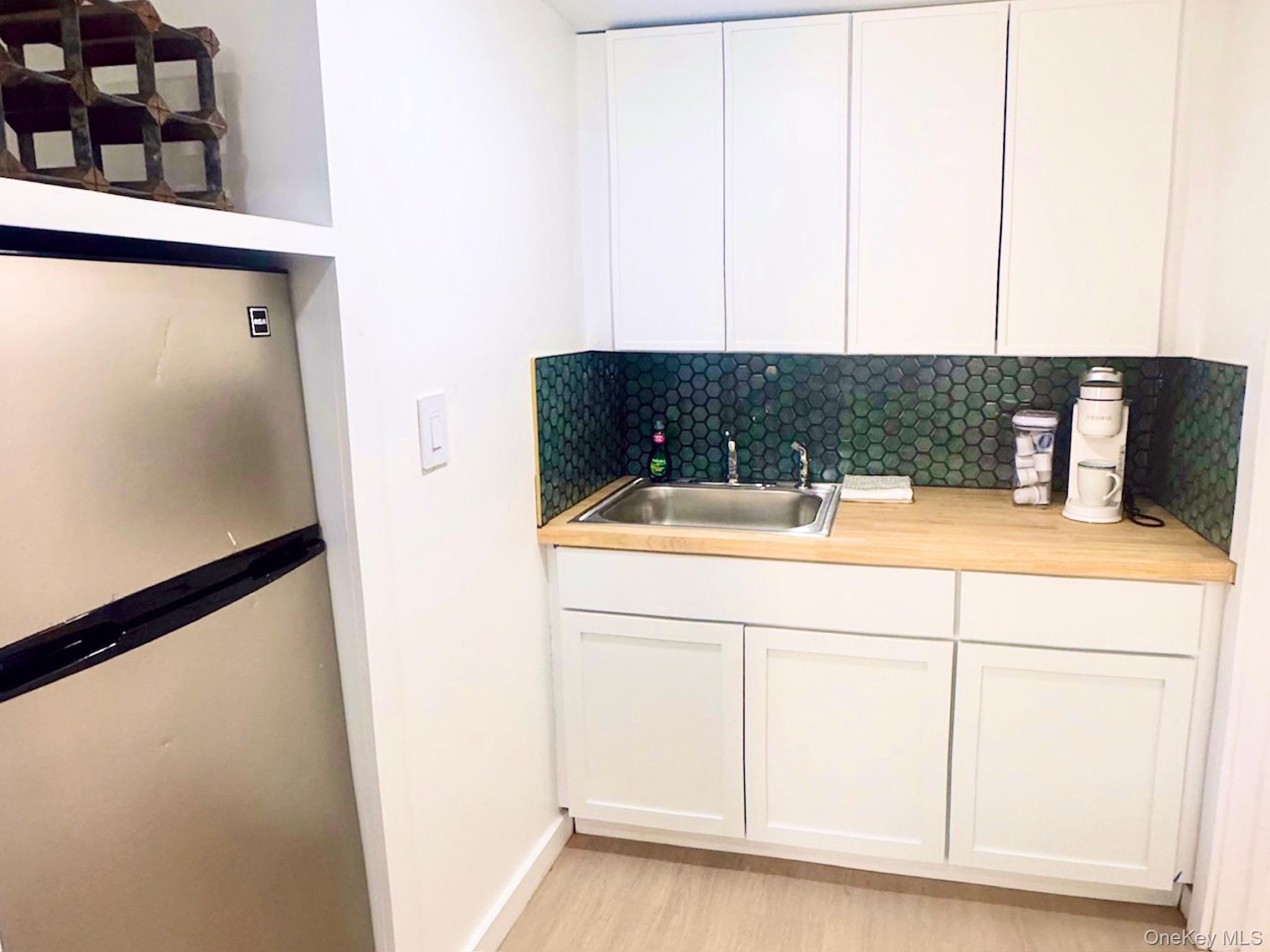 67 West Shore Road Kauneonga Lake, NY 12749 - Photo 10 of 17 Bar with freestanding refrigerator, a sink, decorative backsplash, baseboards, and light wood finished floors