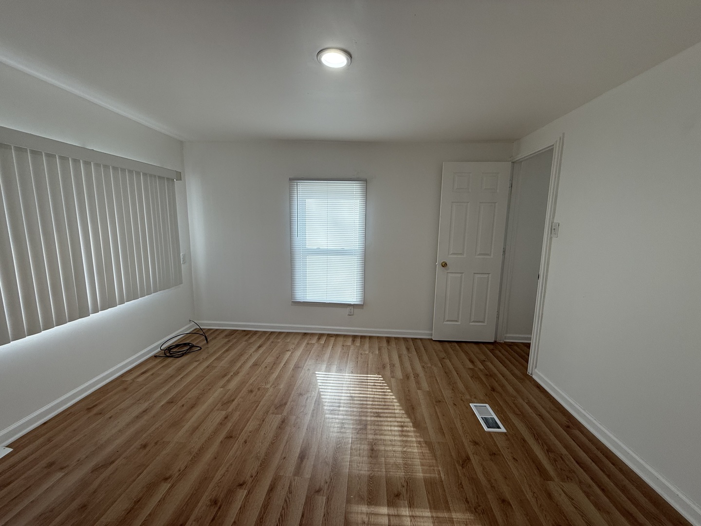 605 Tanglewood Road Matteson, IL 60443 - Photo 16 of 18 an empty room with wooden floor and windows