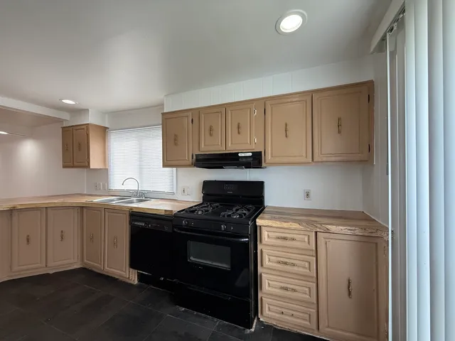 a kitchen with cabinets appliances and a sink