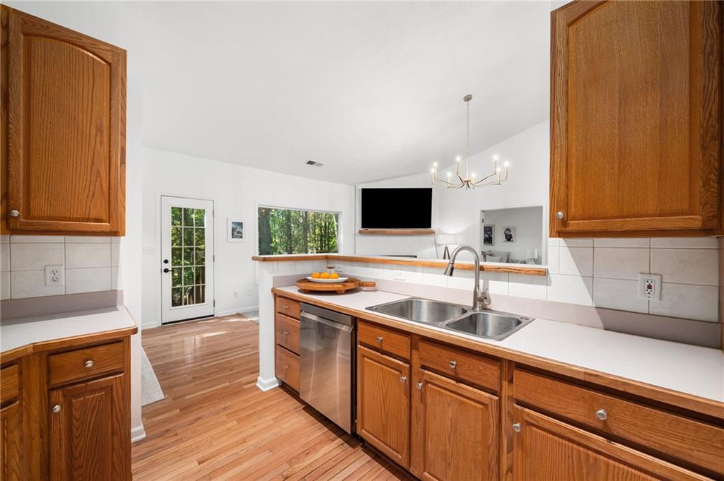 16218 Henderson Road Milton, GA 30004 - Photo 20 of 70 a kitchen with stainless steel appliances granite countertop a sink and a stove with wooden floor