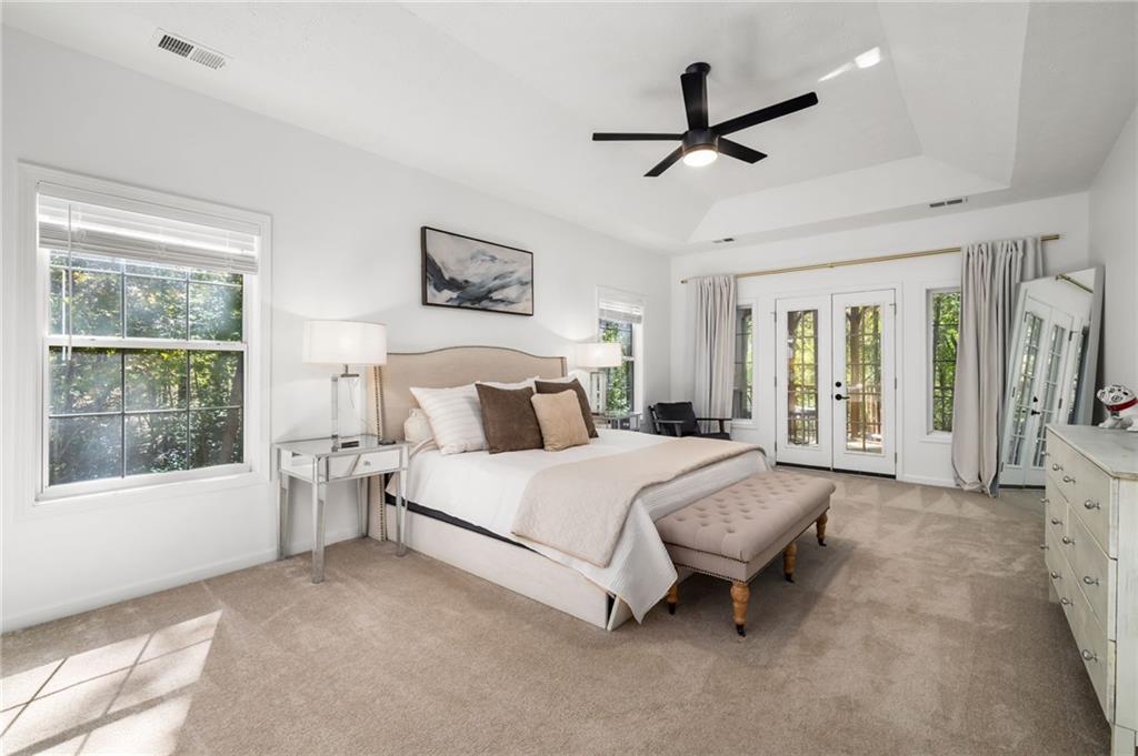 16218 Henderson Road Milton, GA 30004 - Photo 24 of 70 a spacious bedroom with a bed a chandelier and a large window