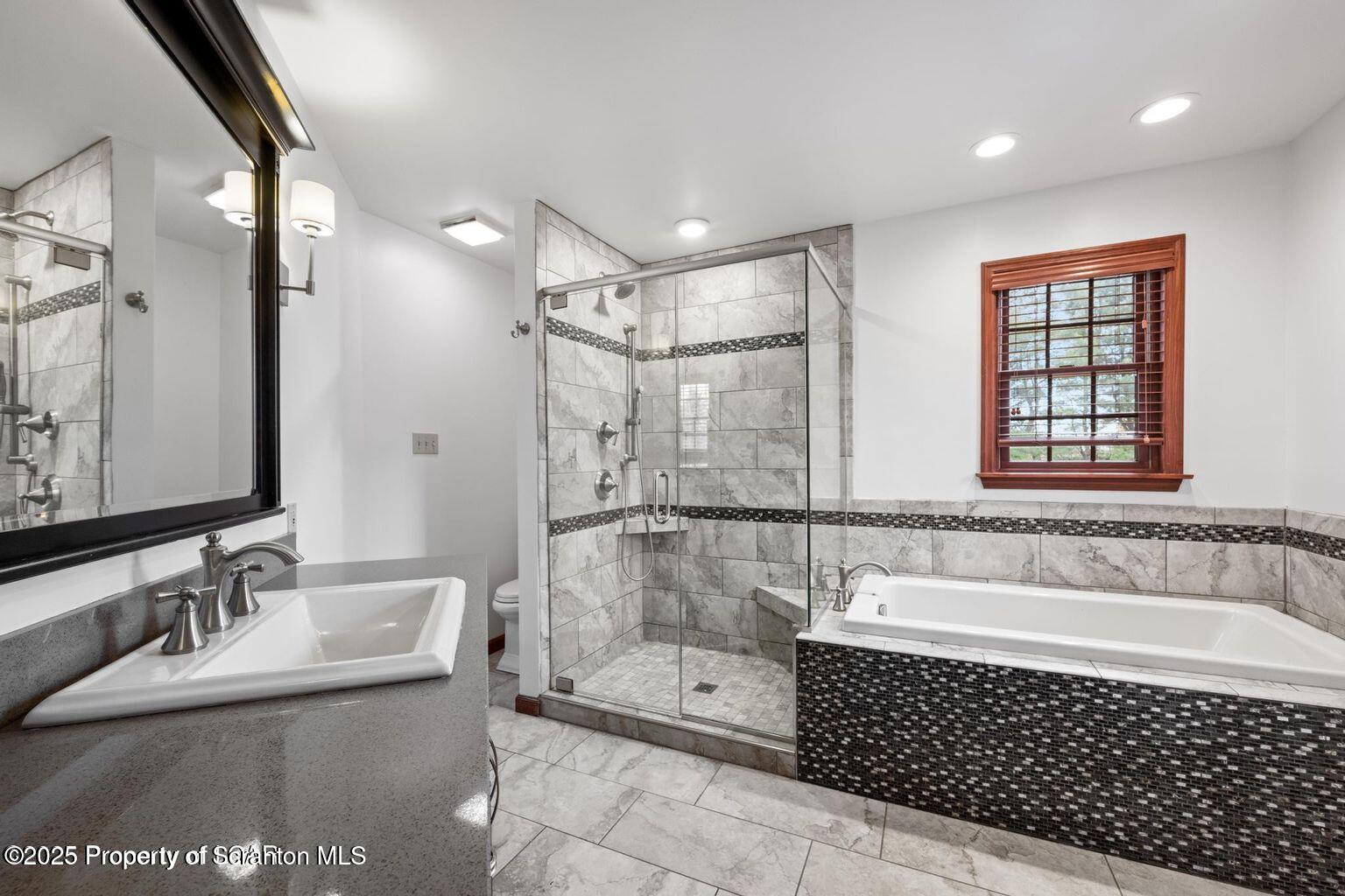 1266 Ryman Road Dallas, PA 18612 - Photo 30 of 73 a bathroom with a tub a sink a mirror and a shower