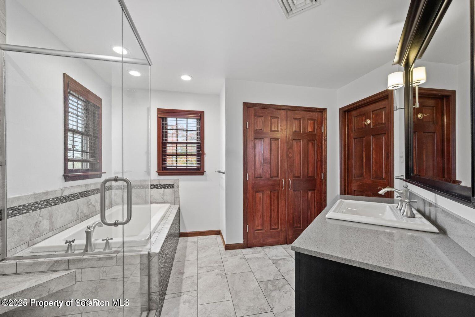 1266 Ryman Road Dallas, PA 18612 - Photo 31 of 73 a bathroom with a sink double vanity granite tub shower and a mirror