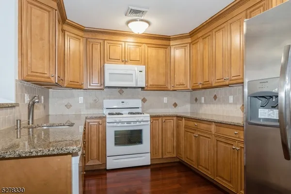 a kitchen with stainless steel appliances granite countertop a sink and cabinets