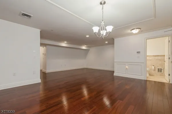 a view of a big room with wooden floor and windows
