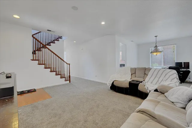 a living room with furniture and stairs