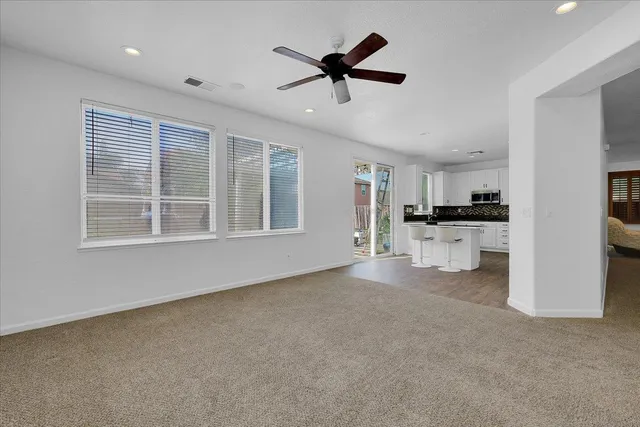 a view of empty room with wooden floor and windows