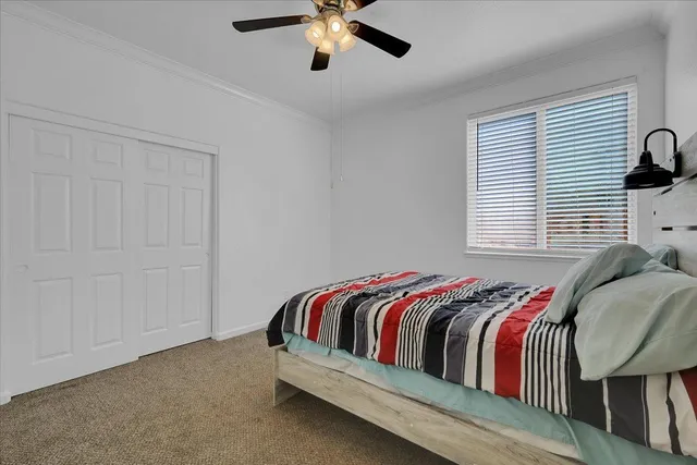 a bed sitting in a bedroom next to a window and a chandelier