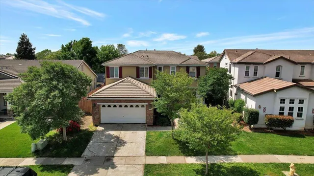 an aerial view of a city with lots of residential buildings and ocean view in back