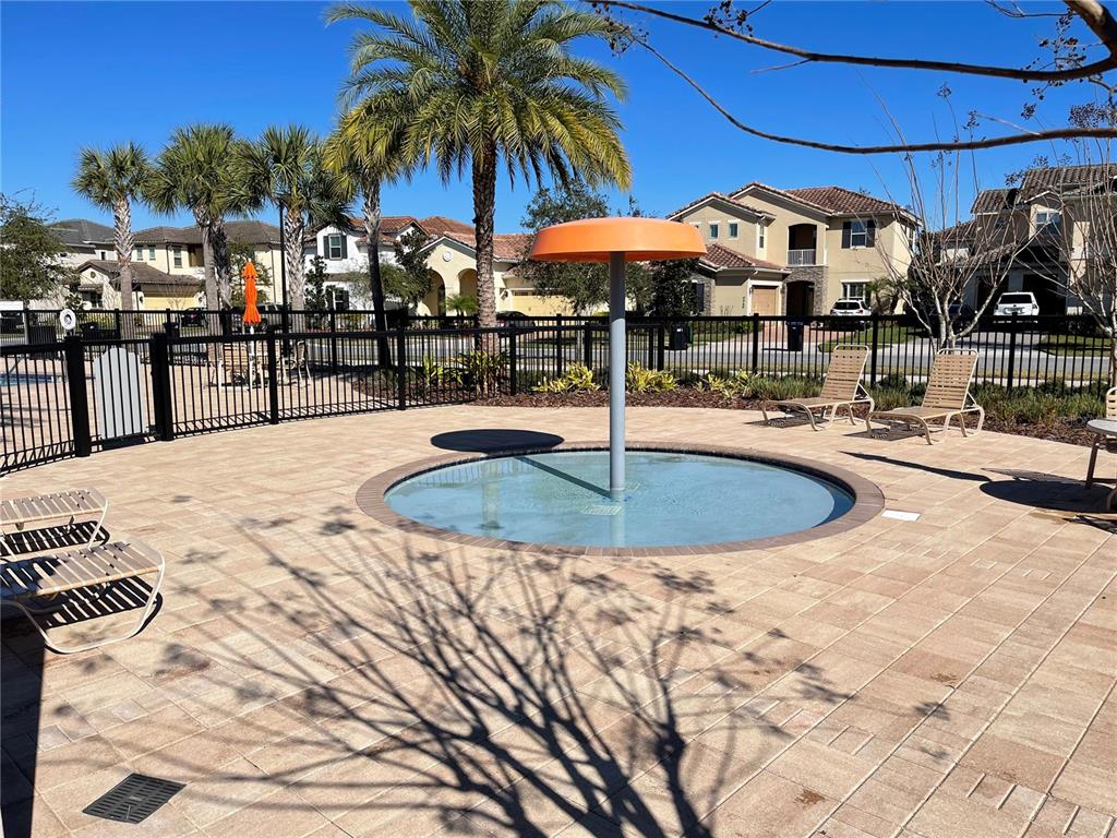9799 Winnington Street Orlando, FL 32832 - Photo 52 of 78 a view of a swimming pool with a table and chairs under an umbrella
