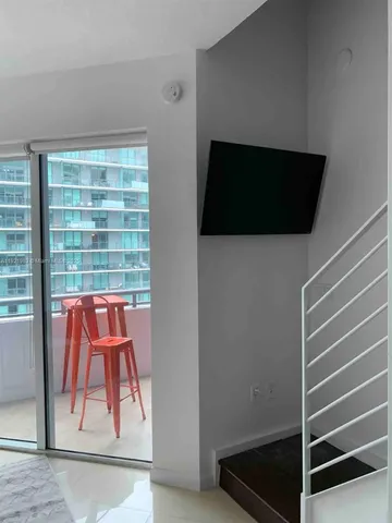 a view of room with door and wooden floor