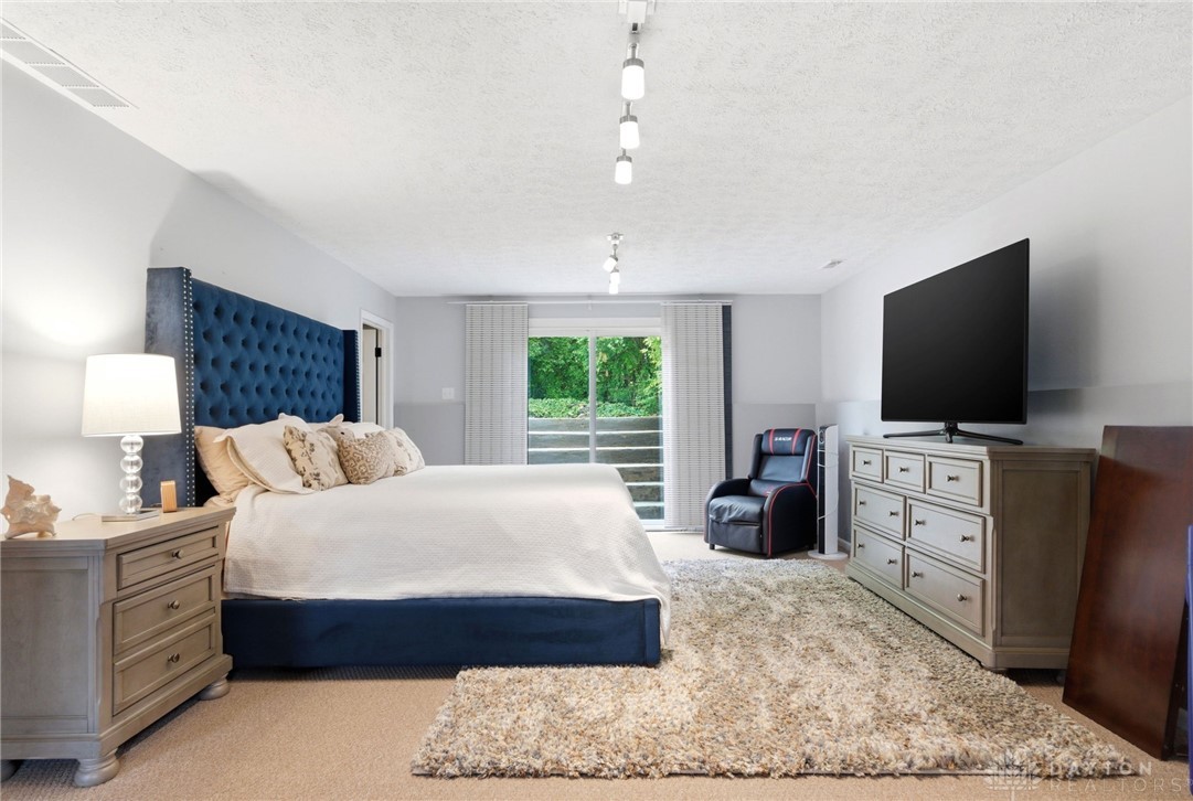 8916 Paragon Road Dayton, OH 45458 - Photo 25 of 33 This expansive bedroom offers direct outdoor access and comfortable flooring, creating a serene retreat.