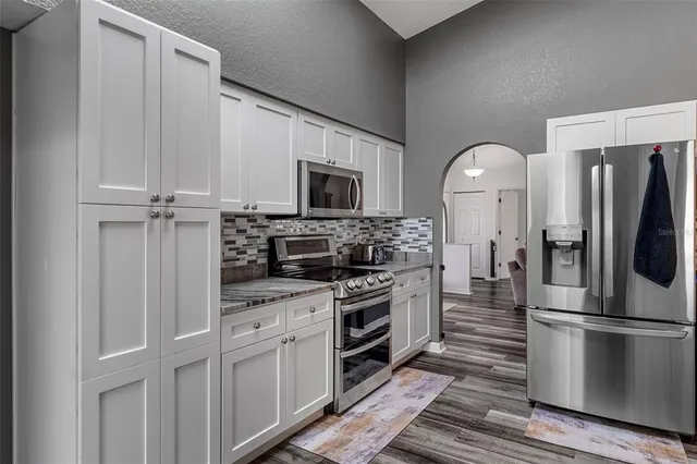 a kitchen with stainless steel appliances a refrigerator stove and microwave