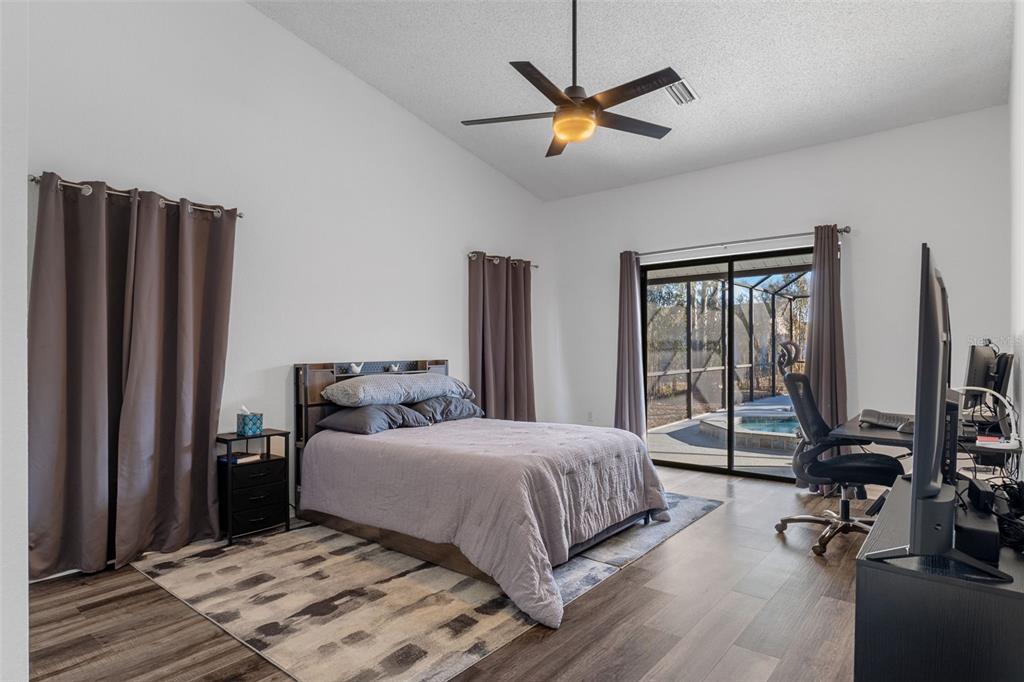 10918 Midland Bridge Road Hudson, FL 34667 - Photo 19 of 42 a bedroom with a large bed and a chandelier