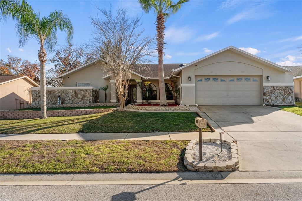 10918 Midland Bridge Road Hudson, FL 34667 - Photo 2 of 42 a front view of a house with garden